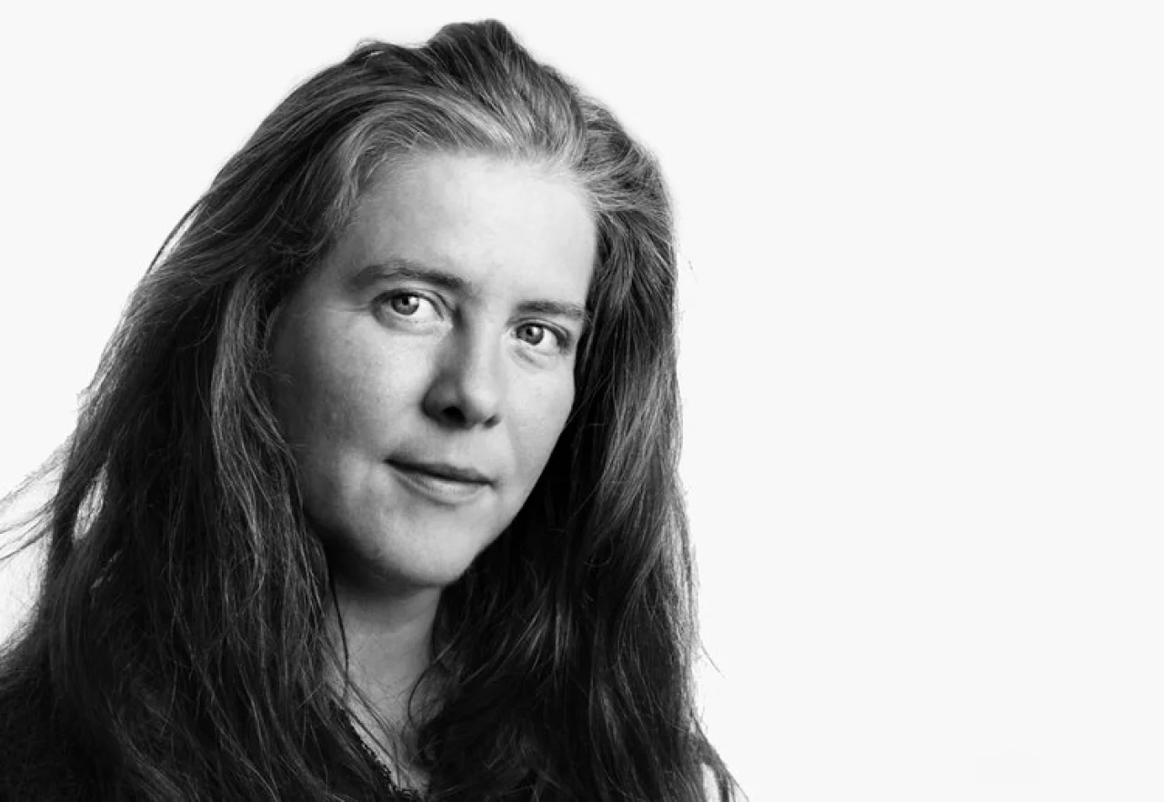 This is a headshot of Ruth in black and white. She is on the left of the photo, looking at the camera, and has long hair which frames her face.